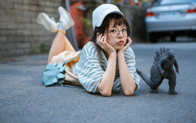 Девушка азиатка с фигуркой годзиллы