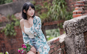 Красивая азиатка с цветком в руке