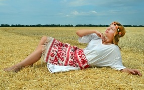 Красивая девушка украинка лежит на соломе