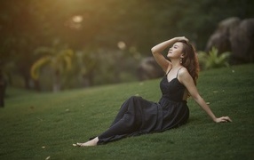 Красивая азиатка с закрытыми глазами в черном платье