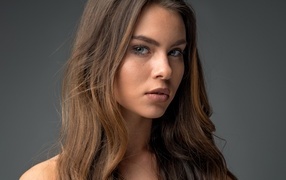 Красивая девушка шатенка на сером фоне 