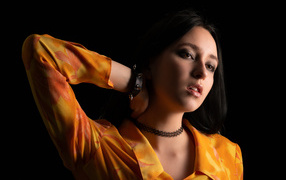 Красивая девушка шатенка с рукой в волосах на черном фоне