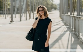 Красивая девушка в черном платье в очках