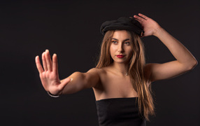 Красивая девушка в кепке на черном фоне