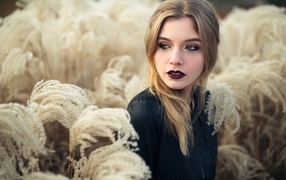 Красивая девушка с макияжем на лице позирует на природе