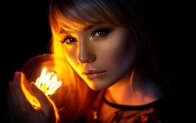 Brown-eyed girl with a light bulb in her hands