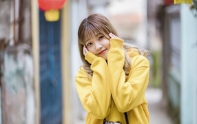 Милая девушка азиатка в желтом свитере