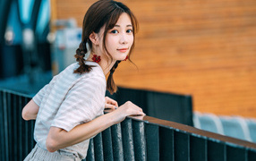 Милая девушка азиатка с косичками на голове 