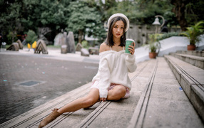 Милая азиатка в с кофе в руках 