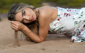 Милая девушка лежит на песке