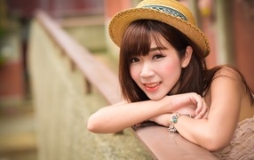 Милая улыбка азиатки в соломенной шляпе 