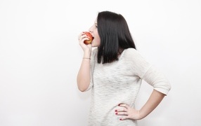 Девушка кусает красное яблоко 