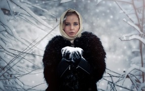 Девушка в черной шубе в заснеженном лесу