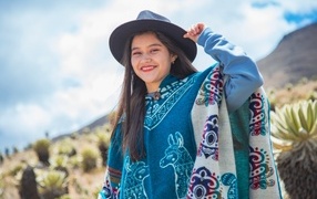 Девушка в ковбойской шляпе и пончо