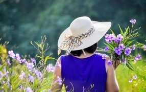 Девушка в шляпе с букетом полевых цветов