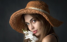 Девушка в шляпе с цветами орхидеи