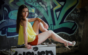 Девушка в заброшенном здании на фоне граффити