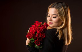 Girl with a bouquet of red roses in her hands