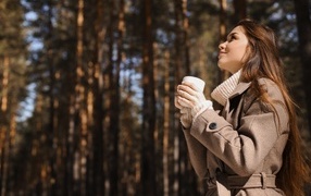 Девушка с чашкой кофе в парке