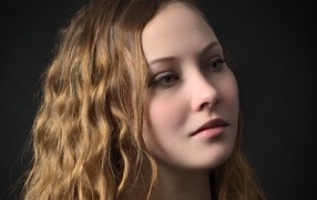 Длинноволосая кареглазая девушка на черном фоне