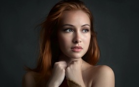 Рыжеволосая девушка с красивыми серыми глазами на сером фоне