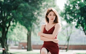 Серьезная девушка азиатка в красном платье