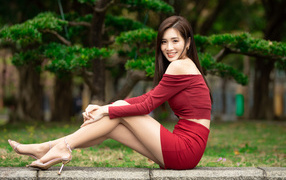 Улыбающаяся азиатка в красном костюме