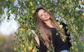 Улыбающаяся девушка в ветках березы