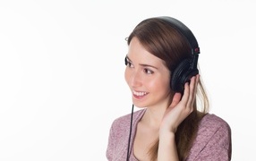 Улыбающаяся девушка в черных наушниках