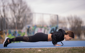 Спортивная девушка отжимается от земли