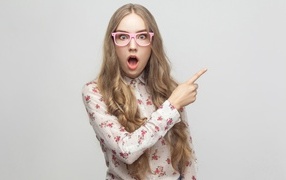 Удивленная девушка на сером фоне