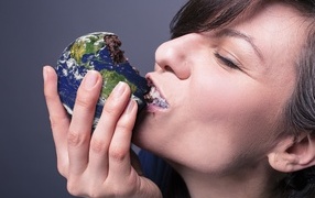 Девушка ест пирожное в виде планеты земля