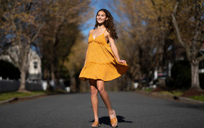 Молодая девушка в коротком платье на дороге  летом