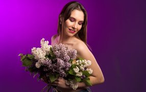 Молодая девушка с букетом ароматной сирени