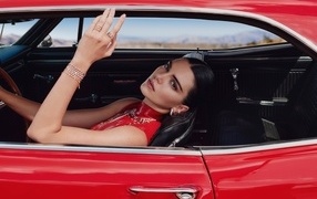 Model Kendall Jenner in a red car