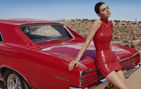 Model Kendall Jenner stands by a red car