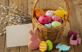 Basket with Easter decorations on a table with willow branches, template for a card