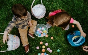 Дети играют на траве с пасхальными яйцами