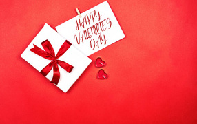Postcard and gift on a red background for Valentine's Day
