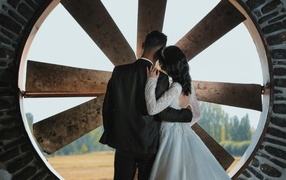 Влюбленные жених и невеста стоят у окна