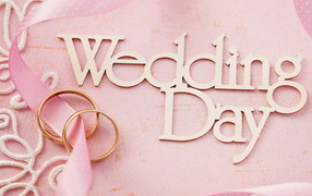 Wedding rings and inscription on a pink background