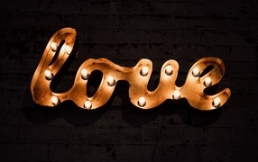 Светящаяся надпись любовь на черной стене