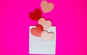 Hearts with white envelope on pink background