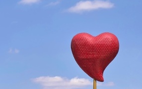 Red heart on a stick against the sky