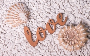 Ракушки и надпись любовь на белых камнях