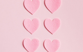 Small paper hearts on a pink background