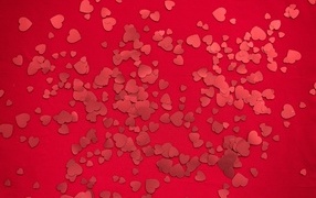 Small paper hearts on a red background