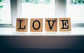 The inscription love on wooden cubes on the window