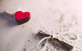 Two wooden hearts with a note on the table