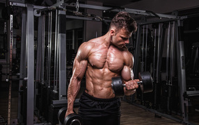 Сильный мужчина качает мускулы 